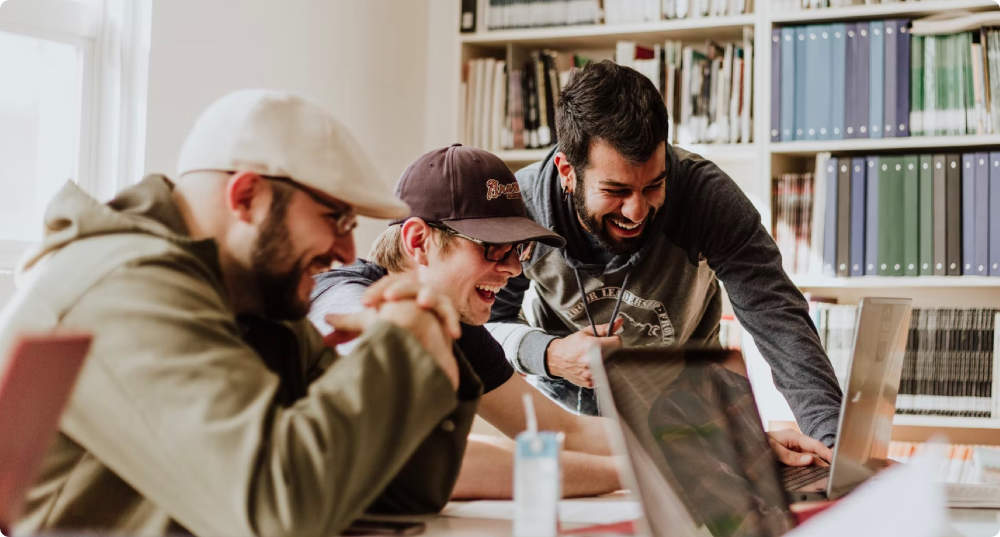 Three Men Looking at a Laptop Photo